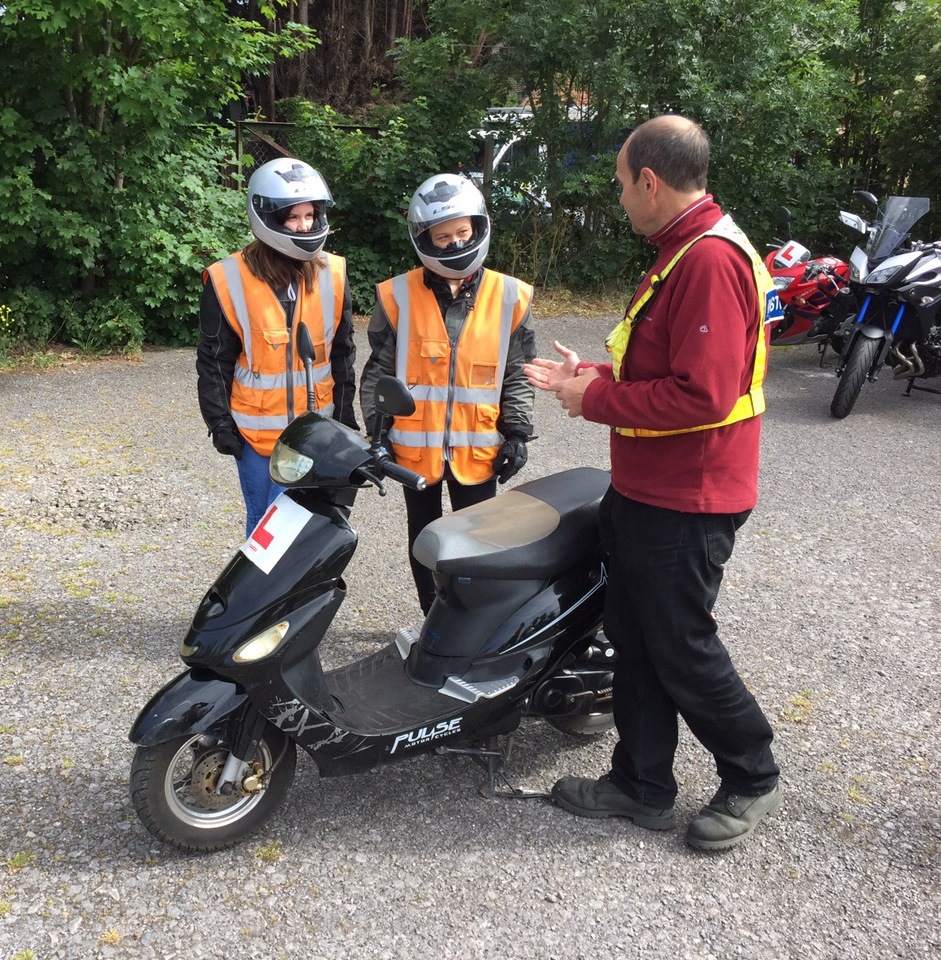 Riding instructor explaining the controls of the moped