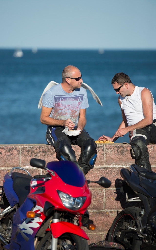 Two bikers eating chips